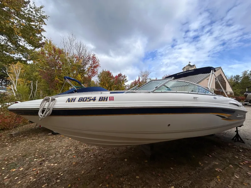Slide: The Image of 2002 Chaparral 220 SSi boat on land, surrounded by autumn trees and cloudy sky. - 9