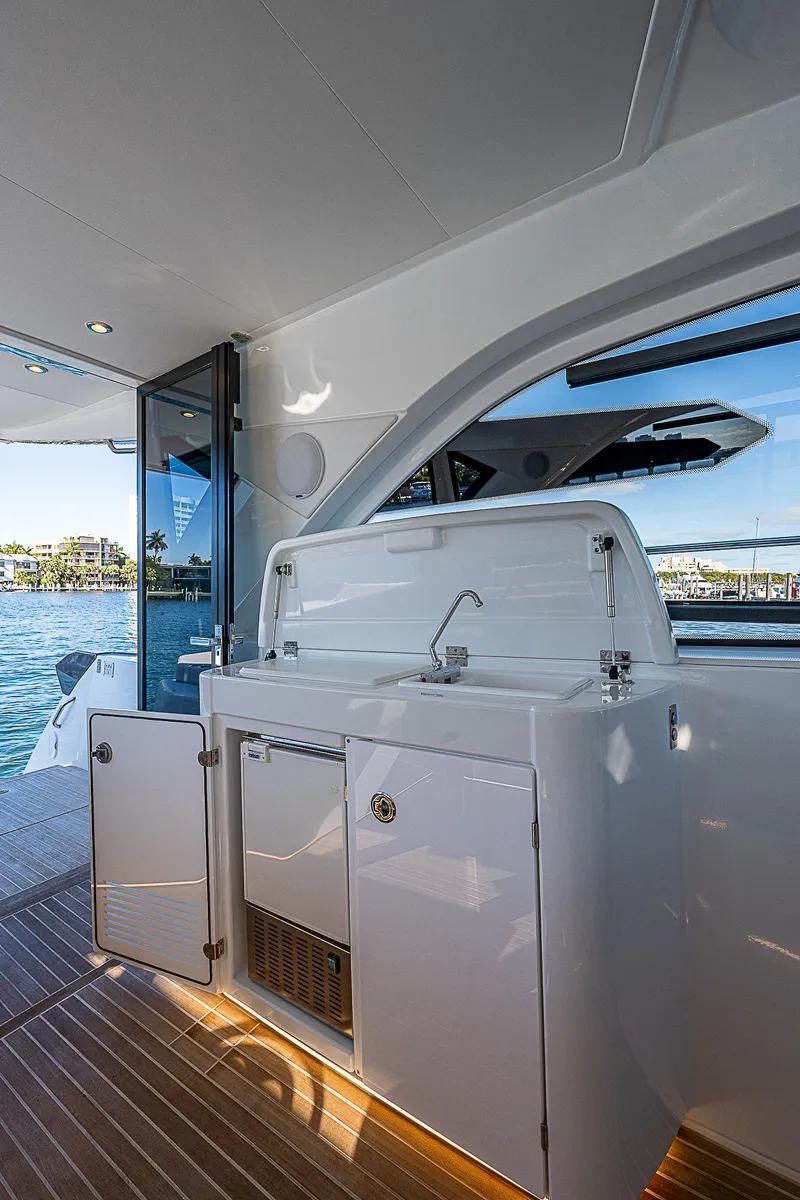 Slide: The Image of 2022 Beneteau Gran Turismo 45 yacht interior with kitchenette and scenic water view. - 45