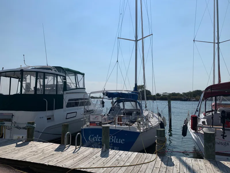 Slide: The Image of Sailboats docked at a marina, featuring a 1985 Hunter Legend 40. - 1