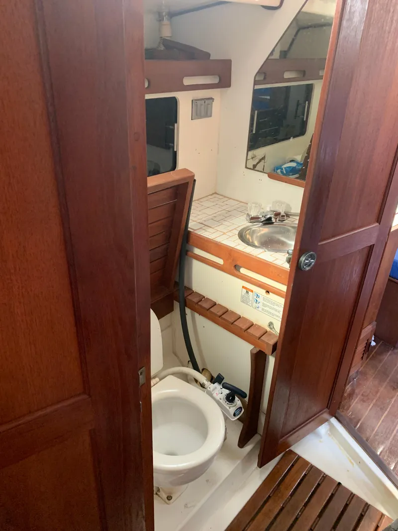 Slide: The Image of 1985 Hunter Legend 40 yacht bathroom with wooden accents and compact design. - 10