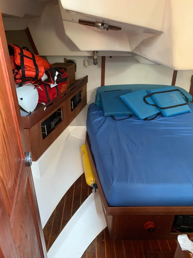 Slide: The Image of Interior cabin of 1985 Hunter Legend 40 sailboat with blue bedding and storage. - 12