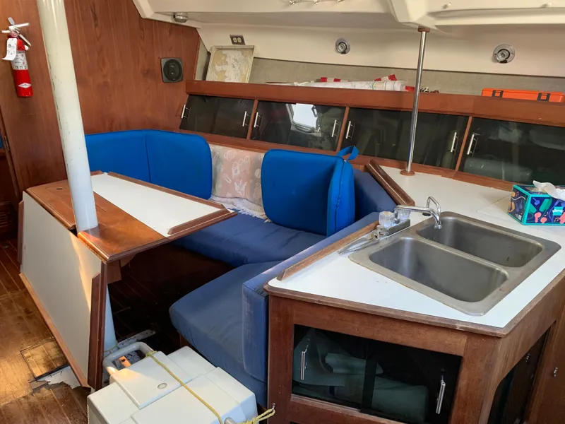 Slide: The Image of Interior of 1985 Hunter Legend 40 sailboat with blue seating, wooden table, and kitchenette. - 18