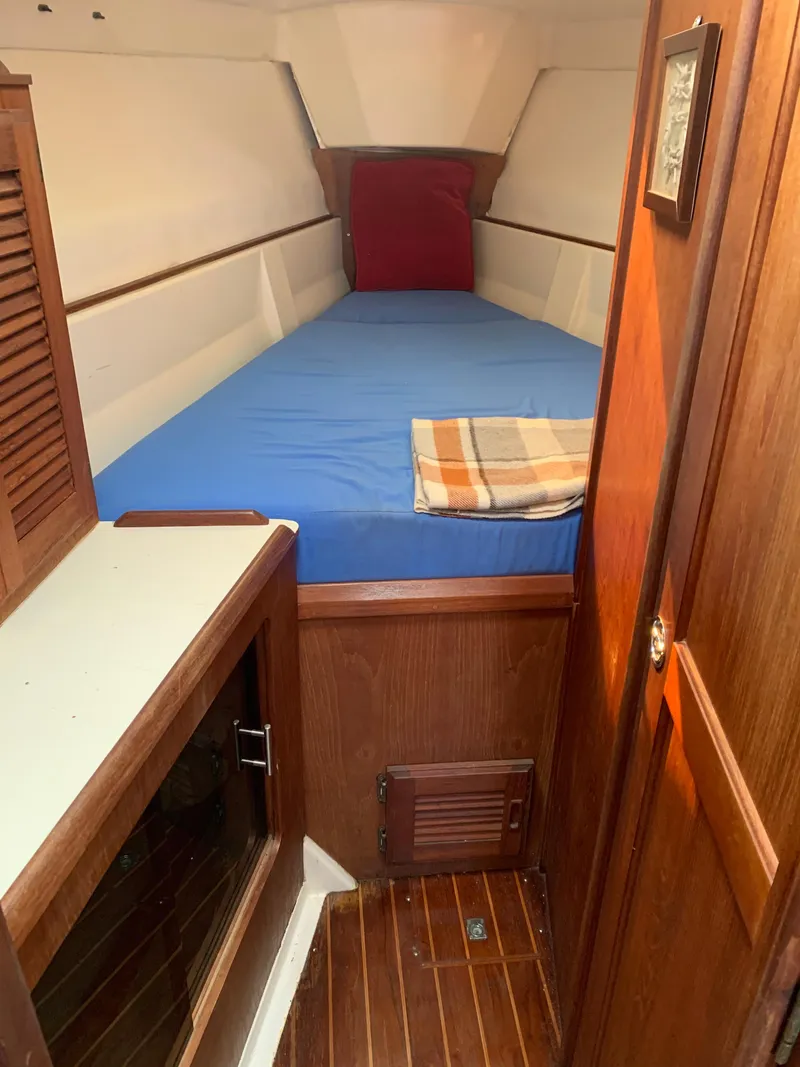 Slide: The Image of 1985 Hunter Legend 40 yacht cabin with blue bedding and wooden interior. - 2