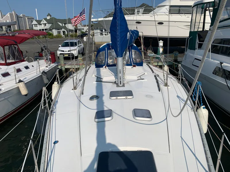 Slide: The Image of 1985 Hunter Legend 40 sailboat docked at marina with American flag in background. - 22