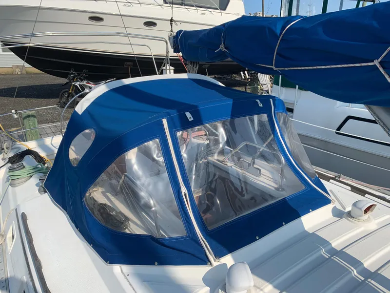 Slide: The Image of 1985 Hunter Legend 40 sailboat with blue canvas cover and clear windows. - 25