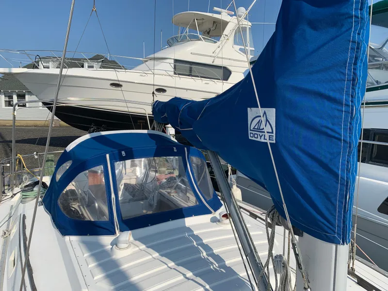 Slide: The Image of 1985 Hunter Legend 40 sailboat with blue Doyle sail cover, docked near a motor yacht. - 26