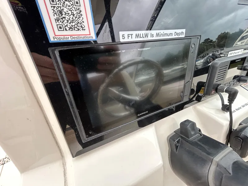 Slide: The Image of Garmin display on 2022 Cobia 240 Dual Console boat dashboard with steering wheel reflection. - 11