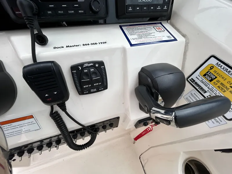 Slide: The Image of Control panel of 2022 Cobia 240 Dual Console boat with throttle and communication devices. - 13