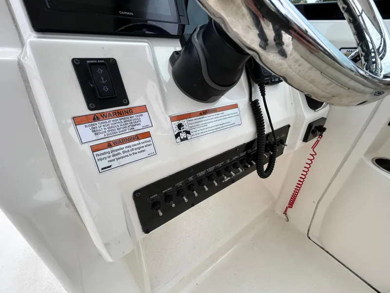 Slide: The Image of 2022 Cobia 240 Dual Console dashboard with steering wheel and control panel. - 14
