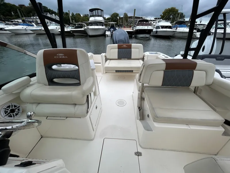 Slide: The Image of 2022 Cobia 240 Dual Console boat interior with seating, docked at marina. - 16