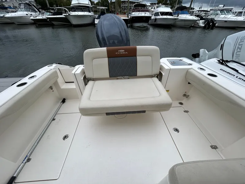 Slide: The Image of 2022 Cobia 240 Dual Console boat interior with seating, docked at marina. - 17