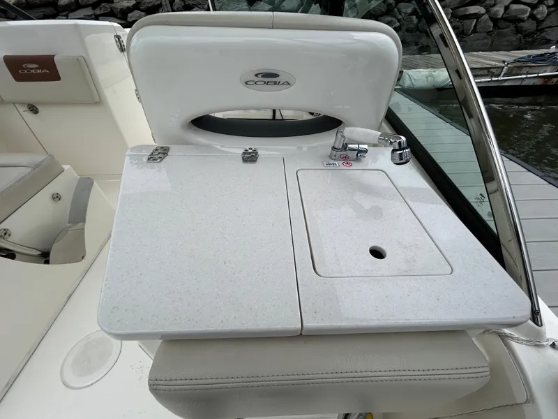 Slide: The Image of 2022 Cobia 240 Dual Console boat with sleek white countertop and sink. - 18