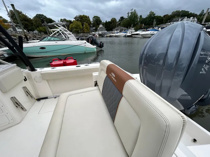 Slide: The Image of 2022 Cobia 240 Dual Console boat in marina, featuring comfortable seating and powerful engine. - 22