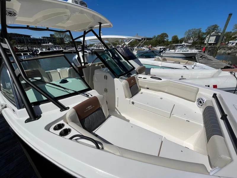 Slide: The Image of 2022 Cobia 240 Dual Console boat with spacious seating and sleek design at a marina. - 24