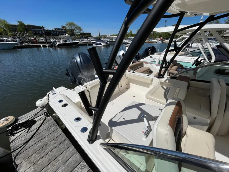 Slide: The Image of 2022 Cobia 240 Dual Console boat docked at marina, featuring spacious seating and sleek design. - 25