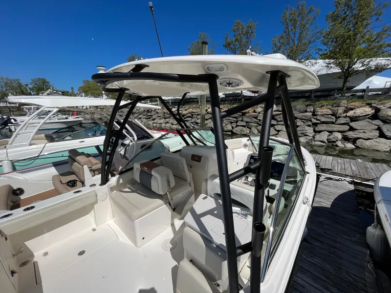 Slide: The Image of 2022 Cobia 240 Dual Console boat docked, featuring spacious seating and sleek design. - 26