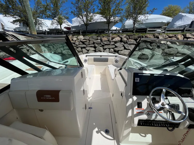 Slide: The Image of 2022 Cobia 240 Dual Console boat interior with steering wheel and seating area. - 28