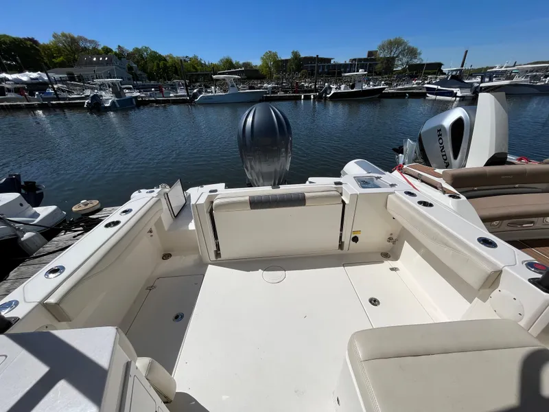Slide: The Image of 2022 Cobia 240 Dual Console boat docked at marina, spacious seating area. - 29