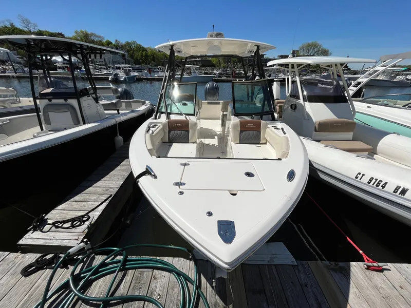 Slide: The Image of 2022 Cobia 240 Dual Console boat docked at marina, sunny day. - 3