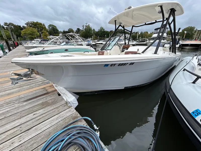 Slide: The Image of 2022 Cobia 240 Dual Console boat docked at marina, overcast sky. - 4