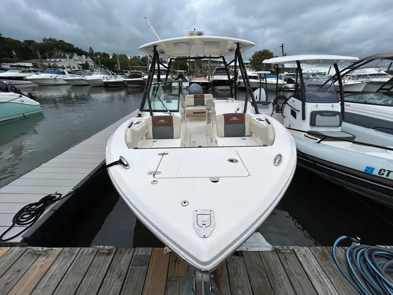 Slide: The Image of 2022 Cobia 240 Dual Console boat docked at marina under cloudy skies. - 5