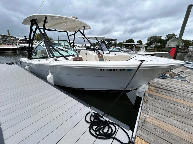 Slide: The Image of 2022 Cobia 240 Dual Console boat docked at marina under cloudy sky. - 6