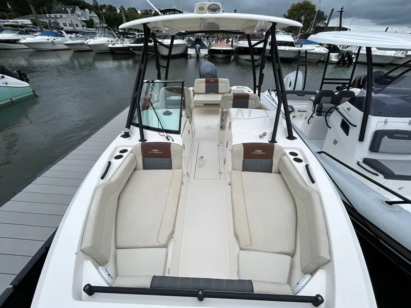 Slide: The Image of 2022 Cobia 240 Dual Console boat docked at marina, featuring spacious seating and sleek design. - 9