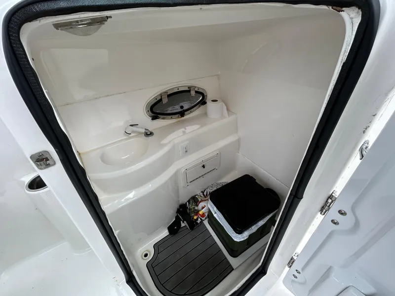 Slide: The Image of 2021 NauticStar 243 DC boat interior bathroom with sink and storage. - 11