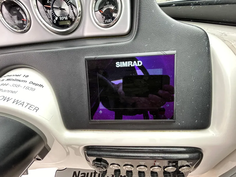 Slide: The Image of Simrad display on 2021 NauticStar 243 DC boat dashboard with gauges and controls. - 14