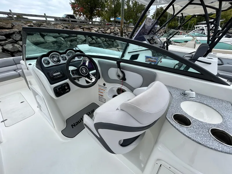 Slide: The Image of 2021 NauticStar 243 DC boat interior with steering wheel and seating. - 18