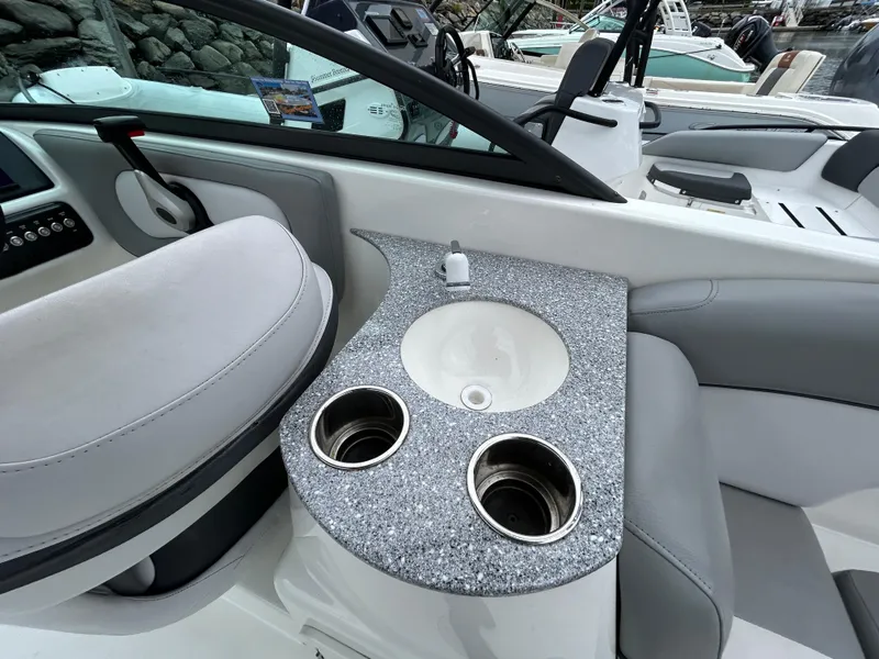 Slide: The Image of 2021 NauticStar 243 DC boat interior with sink and cup holders. - 19