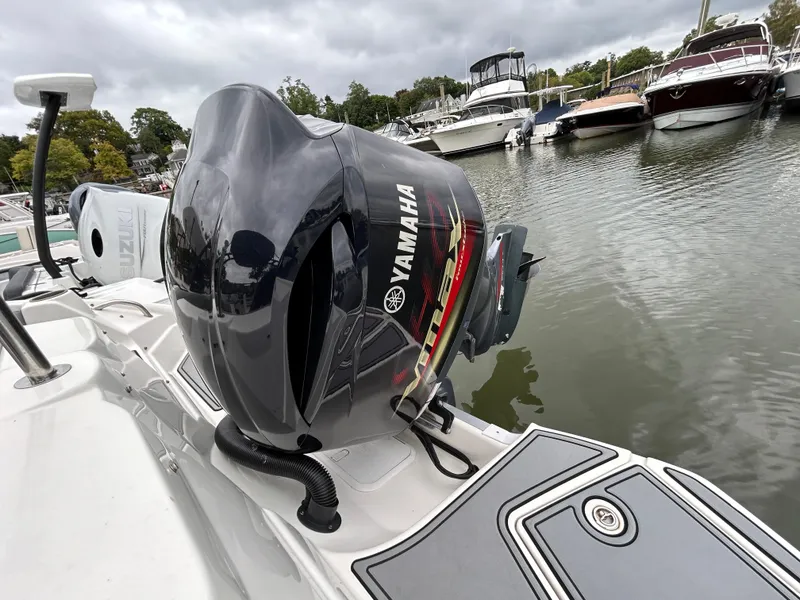 Slide: The Image of 2021 NauticStar 243 DC with Yamaha outboard motor docked in marina. - 23