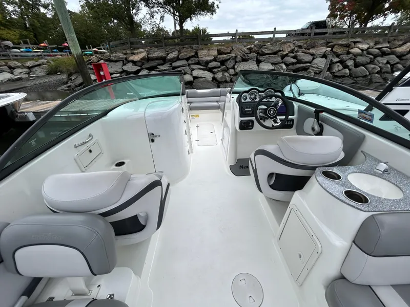 Slide: The Image of 2021 NauticStar 243 DC boat interior with seating and dashboard. - 24