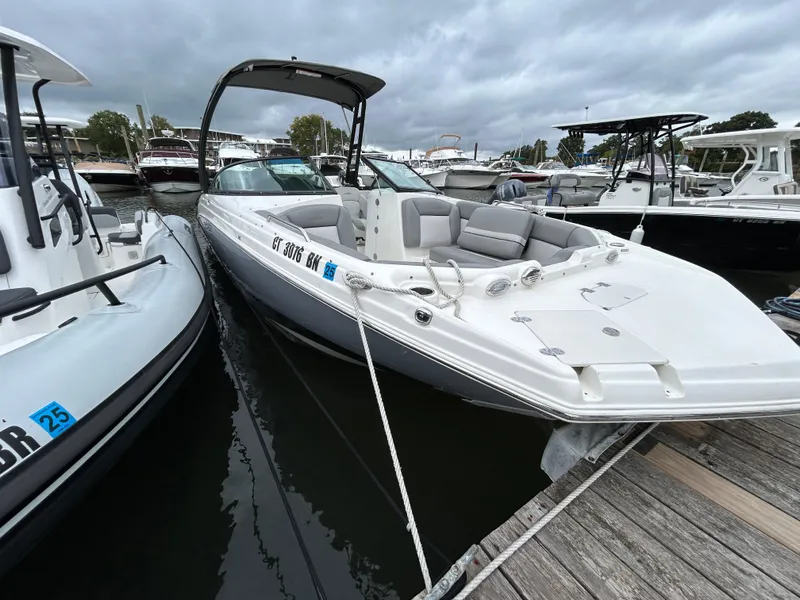 Slide: The Image of 2021 NauticStar 243 DC boat docked at marina under cloudy skies. - 4