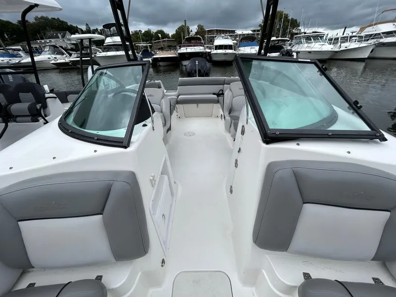 Slide: The Image of 2021 NauticStar 243 DC boat interior with gray seating, docked at marina. - 9