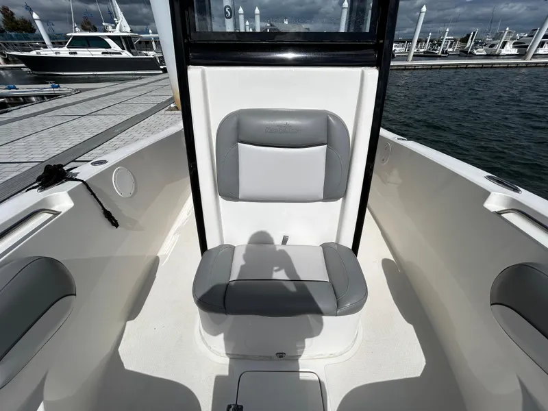 Slide: The Image of 2021 NauticStar 2602 Legacy boat interior with gray seating at dock. - 18