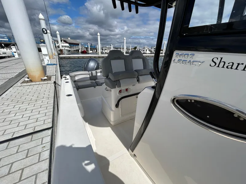 Slide: The Image of 2021 NauticStar 2602 Legacy boat docked at marina under cloudy sky. - 19