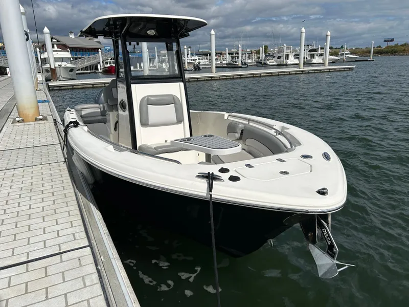 Slide: The Image of 2021 NauticStar 2602 Legacy boat docked at marina under cloudy sky. - 2