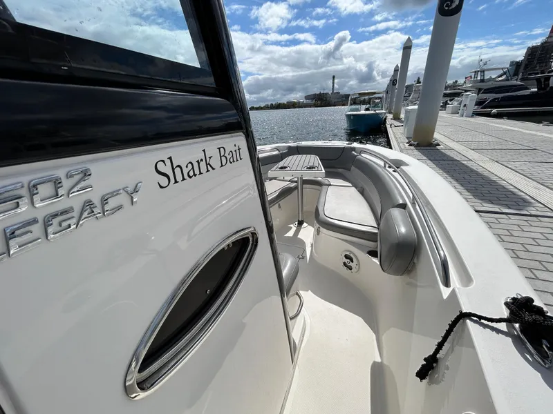 Slide: The Image of 2021 NauticStar 2602 Legacy boat docked, featuring "Shark Bait" name on the side. - 20