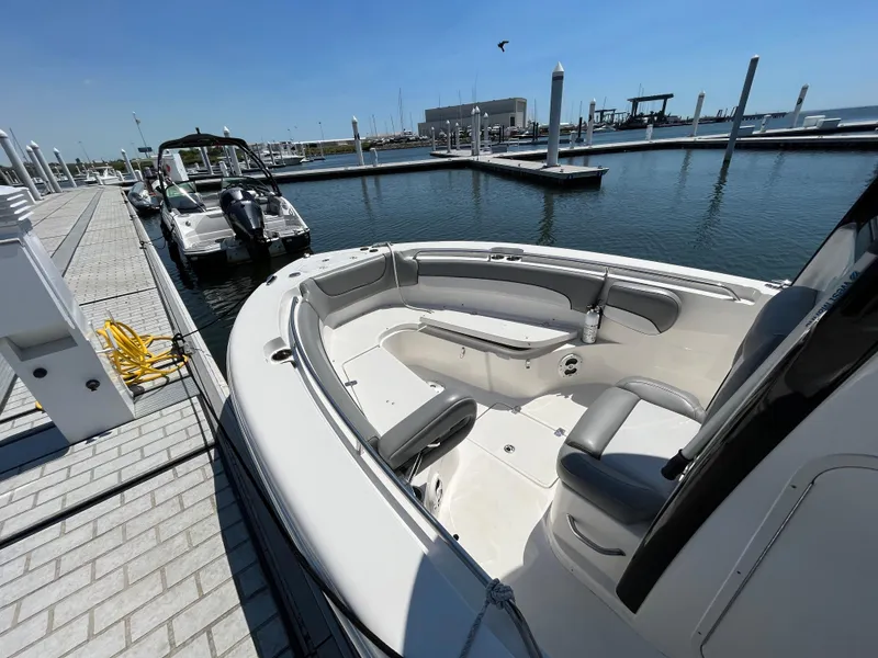 Slide: The Image of 2021 NauticStar 2602 Legacy boat docked at marina under clear blue sky. - 23