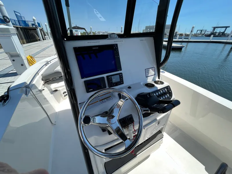Slide: The Image of 2021 NauticStar 2602 Legacy boat console with steering wheel and navigation equipment. - 4