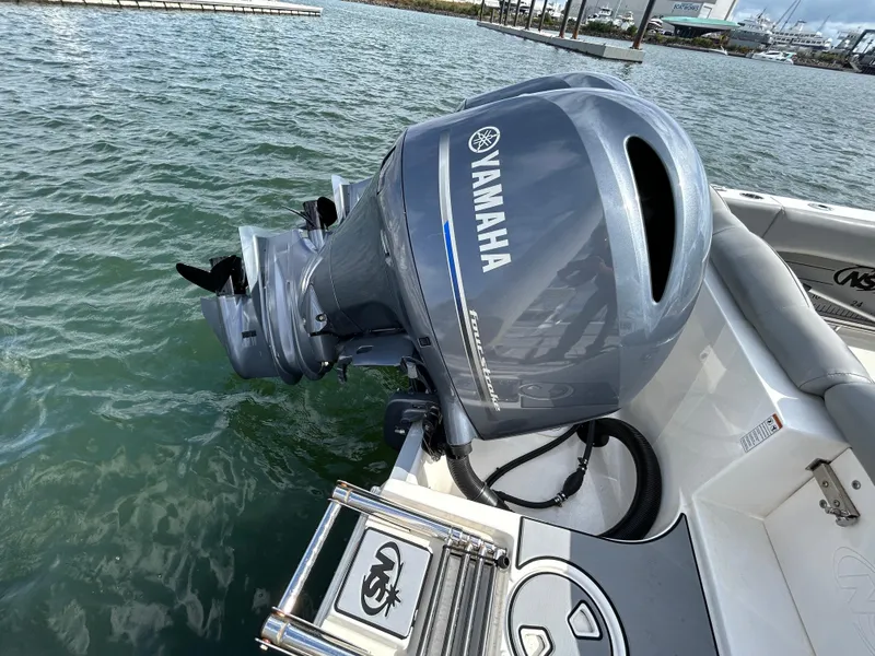 Slide: The Image of 2021 NauticStar 2602 Legacy with Yamaha outboard motor in marina setting. - 5