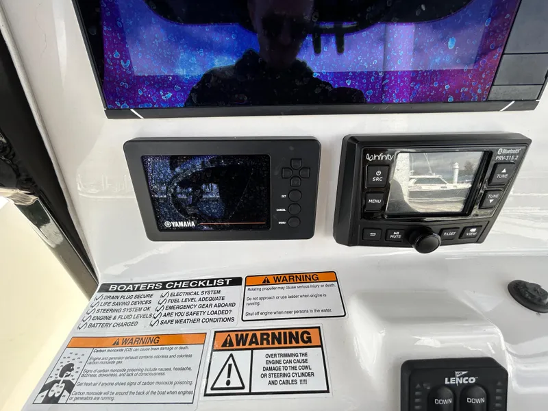 Slide: The Image of Control panel of 2021 NauticStar 2602 Legacy boat with warning labels and displays. - 8