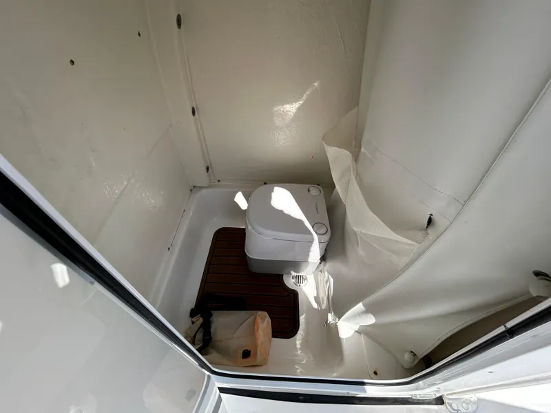 Slide: The Image of 2021 Tidewater 232 LXF boat interior with compact marine toilet. - 11