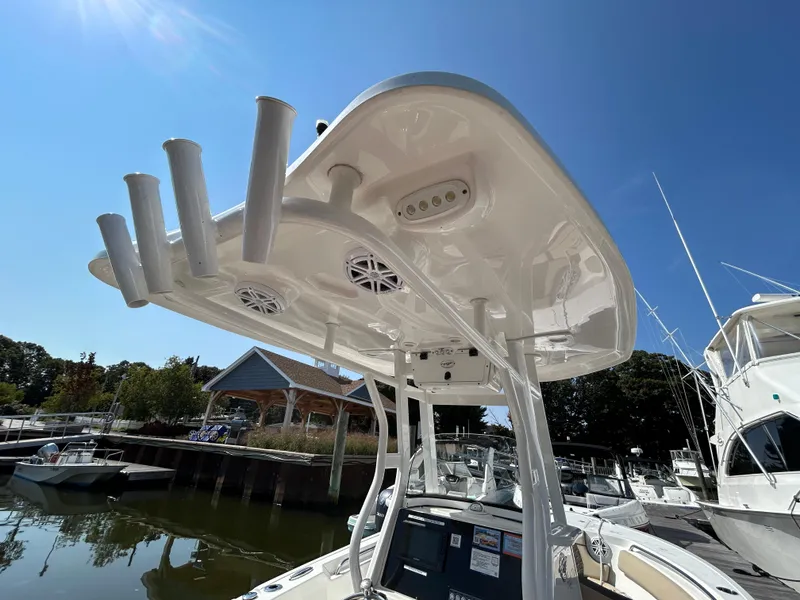 Slide: The Image of 2021 Tidewater 232 LXF boat with T-top and rod holders, docked under clear blue sky. - 15