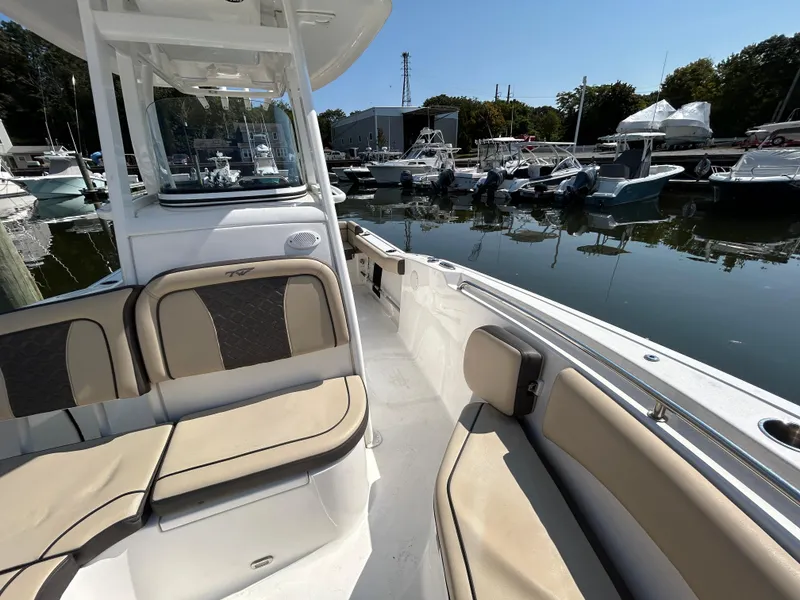 Slide: The Image of 2021 Tidewater 232 LXF boat interior at marina, featuring beige seating and sleek design. - 4