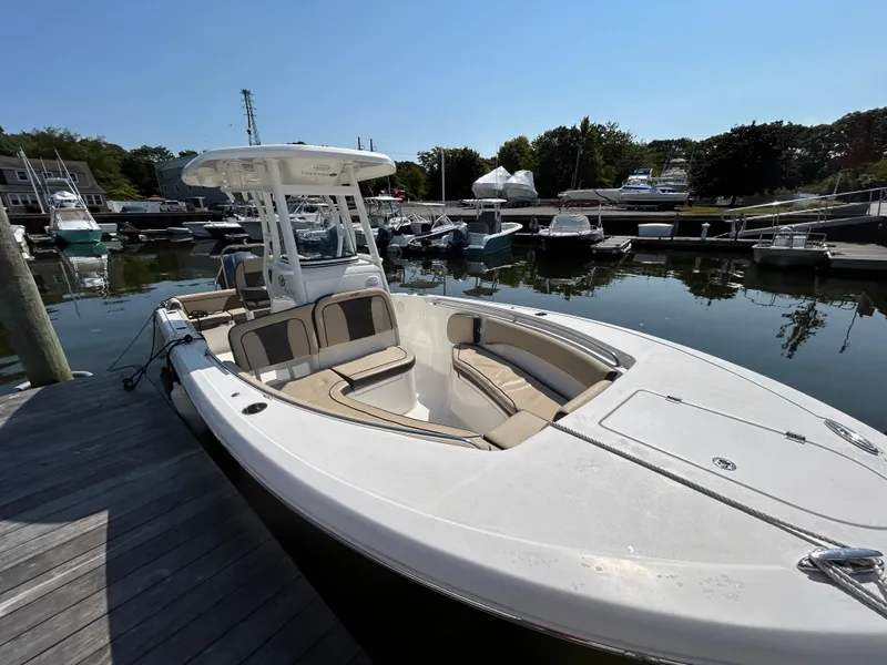 Slide: The Image of 2021 Tidewater 232 LXF boat docked in a marina, featuring spacious seating and sleek design. - 7