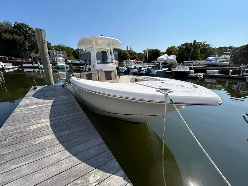 Slide: The Image of 2021 Tidewater 232 LXF boat docked at marina under clear sky. - 9
