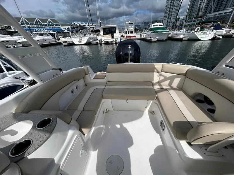 Slide: The Image of 2022 NauticStar 243 DC boat interior at marina, featuring spacious seating and cup holders. - 12