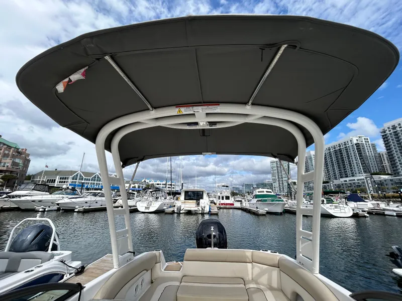 Slide: The Image of 2022 NauticStar 243 DC boat docked at marina with city skyline. - 19